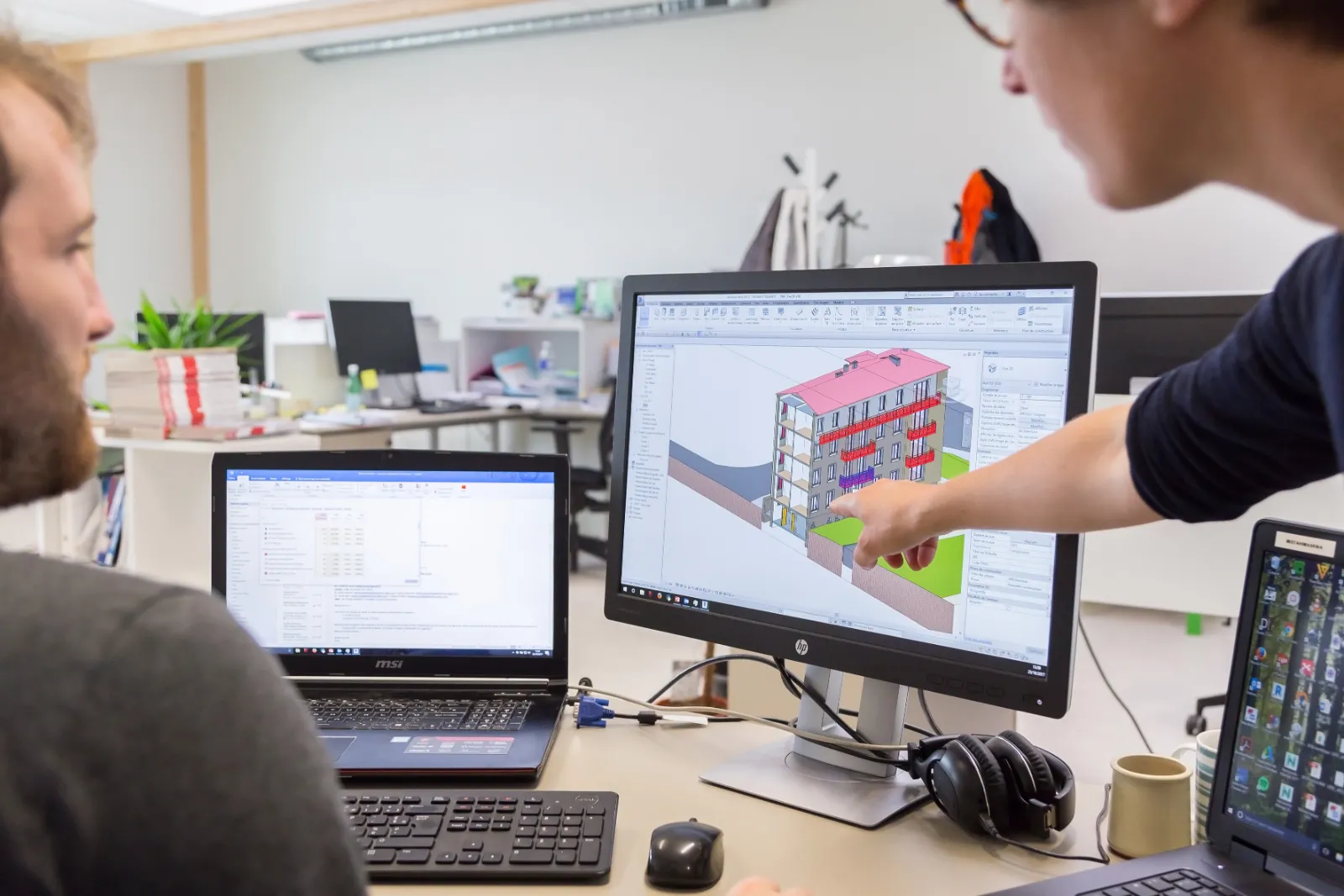 Personne présentant une maquette numérique de bâtiment sur écran